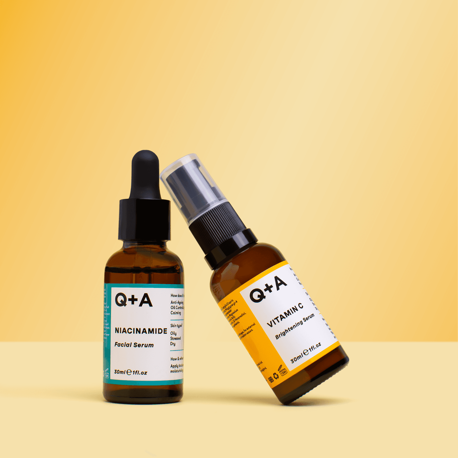 Two Q+A skincare bottles tilted against a bright yellow studio background